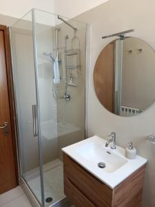 a bathroom with a sink and a shower at Casa nel parco 3 camere 2 bagni 6 ospiti in Luni +29 photos