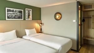 two beds in a room with green walls at Campanile NATURE - Saint-Germain-en-Laye in Saint-Germain-en-Laye +24 photos