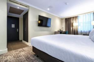 a hotel room with a large bed and a flat screen tv at Doubletree By Hilton London Kensington in London