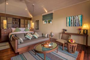 a living room with a couch and a table at Hurawalhi Island Resort in Kuredu