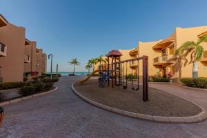 a playground at a resort with palm trees and condos at شاليهات الأحلام لبيوت العطلات in Yanbu
