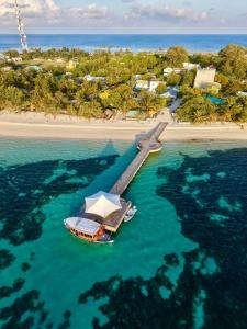a boat in the water next to a beach at Sea Tides Dhangethi in Dhangethi