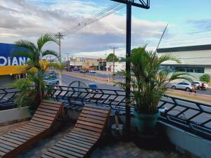 two wooden benches sitting on a balcony with a street at Loft dos sonhos cobertura in Boa Vista