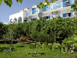 a large white building with trees in front of it at Pansion Ivan in Sućuraj