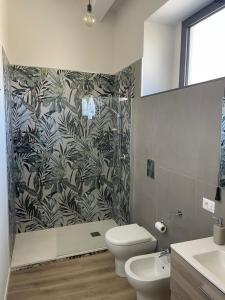 a bathroom with a shower and a toilet and a sink at Alsama in Canicattì