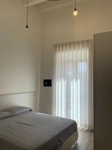 a bedroom with a bed and a large window at Alsama in Canicattì
