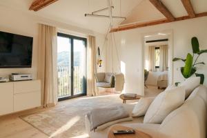 a living room with a white couch and a television at Almhaus Kloster 38 in Kloster