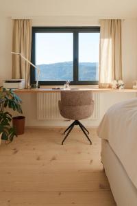 a bedroom with a desk and a chair in front of a window at Almhaus Kloster 38 in Kloster +63 photos