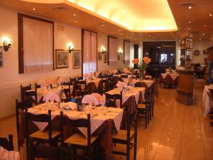 a dining room with tables and chairs in a restaurant at Hotel Touring in Sottomarina
