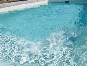 a large swimming pool with blue water in it at Quinta da Fé in Santa Margarida da Coutada