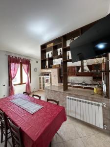 a kitchen with a table with a red table cloth at La Casa del Corso in Bari Sardo