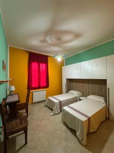 a bedroom with two beds and a red window at La Casa del Corso in Bari Sardo