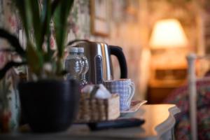 a table with affeepot and a drink bottle on top at The Forester and Flower in Bath