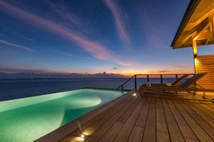a swimming pool on the deck of a house at Hurawalhi Island Resort in Kuredu