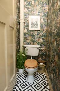 a bathroom with a toilet with a floral wallpaper at The Forester and Flower in Bath