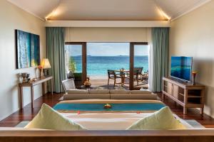 a bedroom with two beds and a view of the ocean at Hurawalhi Island Resort in Kuredu