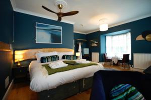 a bedroom with a large bed with blue walls at Arosfa Harbourside Aberaeron in Aberaeron +78 photos