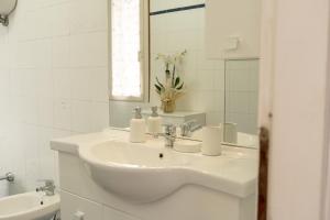 a white bathroom with a sink and a mirror at Palazzo Marini in Spoleto
