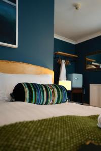 a bed with a colorful pillow on top of it at Arosfa Harbourside Aberaeron in Aberaeron