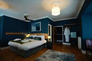a blue bedroom with a bed and a ceiling fan at Arosfa Harbourside Aberaeron in Aberaeron