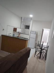 a living room with a couch and a kitchen at Aconchego e tranquilidade é aqui!!!! Te aguardo! in Porto Seguro
