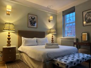 a bedroom with a bed and two lamps and a window at Windsor Castle 4-Bed & Garden in Windsor