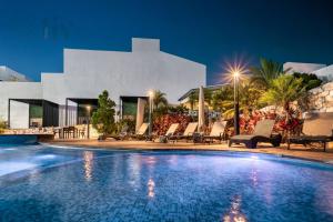 a swimming pool in front of a villa at night at Exclusive Apartment in Home Resort in La Cañada