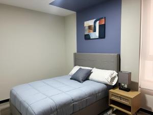a bedroom with a bed with a blue wall at Exclusive Apartment in Home Resort in La Cañada +100 photos