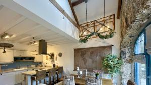 a kitchen and dining room with a table and chairs at Ty Coets in Llanfairpwllgwyngyll