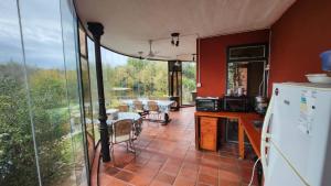 a kitchen with a refrigerator and a table with chairs at Cielo de Piedra. Cabañas y Petit Hotel in Tanti