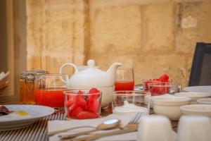a table with plates and cups and a tea kettle at Palazzo Pisani & Spa Malta in Żabbar
