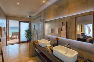 a bathroom with two sinks and a view of the ocean at Hurawalhi Island Resort in Kuredu