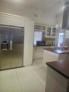 a kitchen with a stainless steel refrigerator and a counter at Ludiz Self Catering Accommodation in Avondale