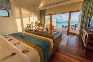 a bedroom with a bed with a view of the ocean at Hurawalhi Island Resort in Kuredu