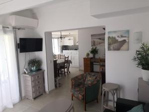 a living room and dining room with a dining table at Villa les volets bleus in Le Grau-dʼAgde