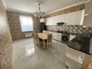 a kitchen with a table and a dining room at Qusar Villa in Uzunmeşǝ
