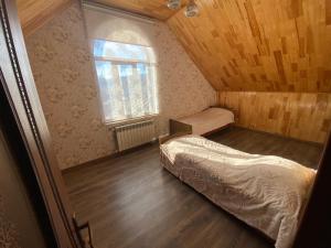 a small bedroom with two beds and a window at Qusar Villa in Uzunmeşǝ