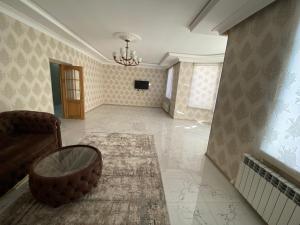 a living room with a couch and a table at Qusar Villa in Uzunmeşǝ