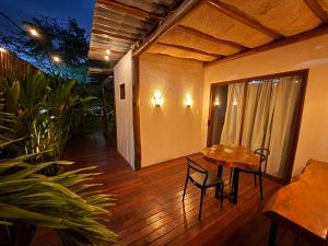 a patio with a table and chairs on a wooden floor at Nari Guest Room in Fernando de Noronha
