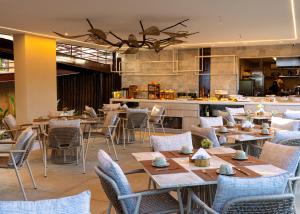 a restaurant with tables and chairs and a kitchen at Pousada Filó in Fernando de Noronha