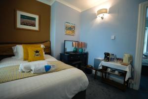 a bedroom with a bed with a yellow pillow at Arosfa Harbourside Aberaeron in Aberaeron
