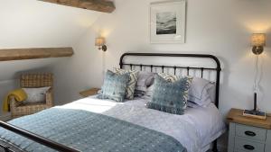 a bedroom with a bed with blue pillows at Ty Coets in Llanfairpwllgwyngyll