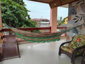 a hammock on the balcony of a house at Pousada Jubarte in Serra