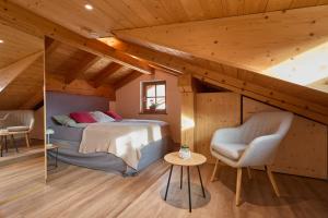 a bedroom with a bed and a chair in a attic at Bergliebe Alpspitze in Garmisch-Partenkirchen