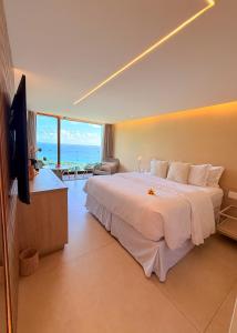 a bedroom with a large bed with a view of the ocean at Pousada Filó in Fernando de Noronha