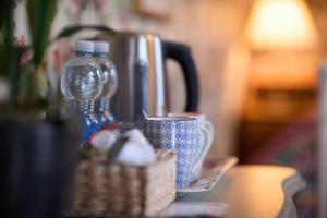a table with a coffee pot and a cup on it at The Forester and Flower in Bath