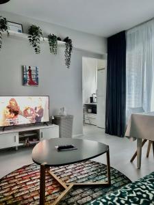 a living room with a tv and a coffee table at Central Studio Apartment in Pori