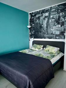 a bedroom with a bed with a blue wall at Central Studio Apartment in Pori