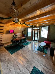 a large living room with a table and chairs at Cabana Doi Brazi A-FRAME in Dămuc