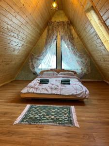 a bedroom with a bed in a attic at Cabana Doi Brazi A-FRAME in Dămuc